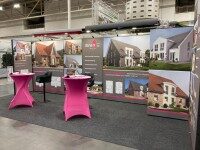 Textiler Messestand mit Rückwand, Kabine und pinken Stehtischen für Danax Bau – gestaltet von der Wrocklage Werbewerkstatt