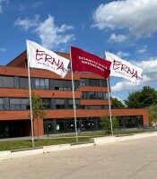 Drei große Fahnen mit Logo der Erna-de-Vries-Gesamtschule, montiert vor dem Schulgebäude – Design und Umsetzung: Wrocklage Werbewerkstatt