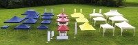 Farbig sortierte Eventzelte, Faltpavillons und Promotionsstände in Blau, Rot, Gelb und Weiß auf einer grünen Wiese. Verschiedene Größen und Formen mit Werbeflächen und Brandingoptionen. Beispiel für mobile Präsentationslösungen bei Veranstaltungen.