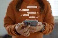 Frau hält Smartphone in der Hand, darüber animierte Chat-Sprechblasen als Symbol für Postfach- und Chatfunktion.