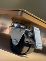 Nahaufnahme eines Rollbrettrads mit schwarzem Rad und silbernen Metallbeschlägen.