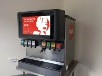 Getränkeautomat mit integriertem Digital Signage Display, zeigt Coca-Cola Werbung und Auswahl an Softdrinks