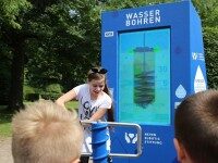 Outdoor-Digital Signage Stele mit interaktivem Display zum Thema Wasser Bohren, Kinder an Pumpe, Neven Subotic Stiftung