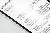 Nahaufnahme von Mobiltelefon und Webseite Nahaufnahme eines Mobiltelefons, das eine Webseite mit Text anzeigt