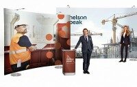 Messestand mit Kombination aus gebogenen und geraden Textilwänden sowie Theke