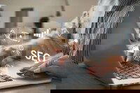 Person arbeitet am Laptop mit digitalen Symbolen für SEO, Analyse und Online-Marketing