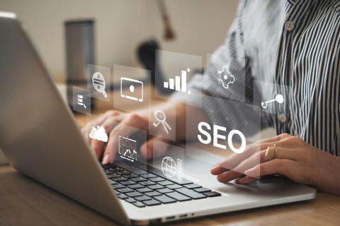 SEO Optimierung – Erfolgreiche Strategien für besseres Online-Ranking Person arbeitet am Laptop mit digitalen Symbolen für SEO, Analyse und Online-Marketing
