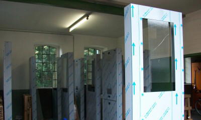 Eine Werkstatt mit mehreren in Plastikfolie eingewickelten Metallsäulen mit Glasfenstern.