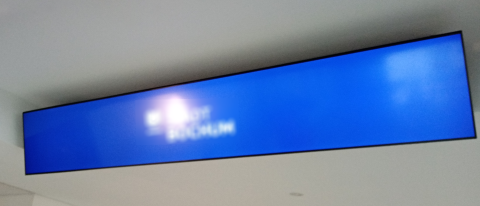 Rückenabdeckung für Monitore mit Deckenbefestigung – elegante Lösung für Informationsdisplays Breitformatiges Display mit Rückenabdeckung an der Decke montiert für saubere Kabelführung