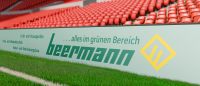 Bandenwerbung mit dem Text 'alles im grünen Bereich' und 'beermann', Fußballstadion im Hintergrund